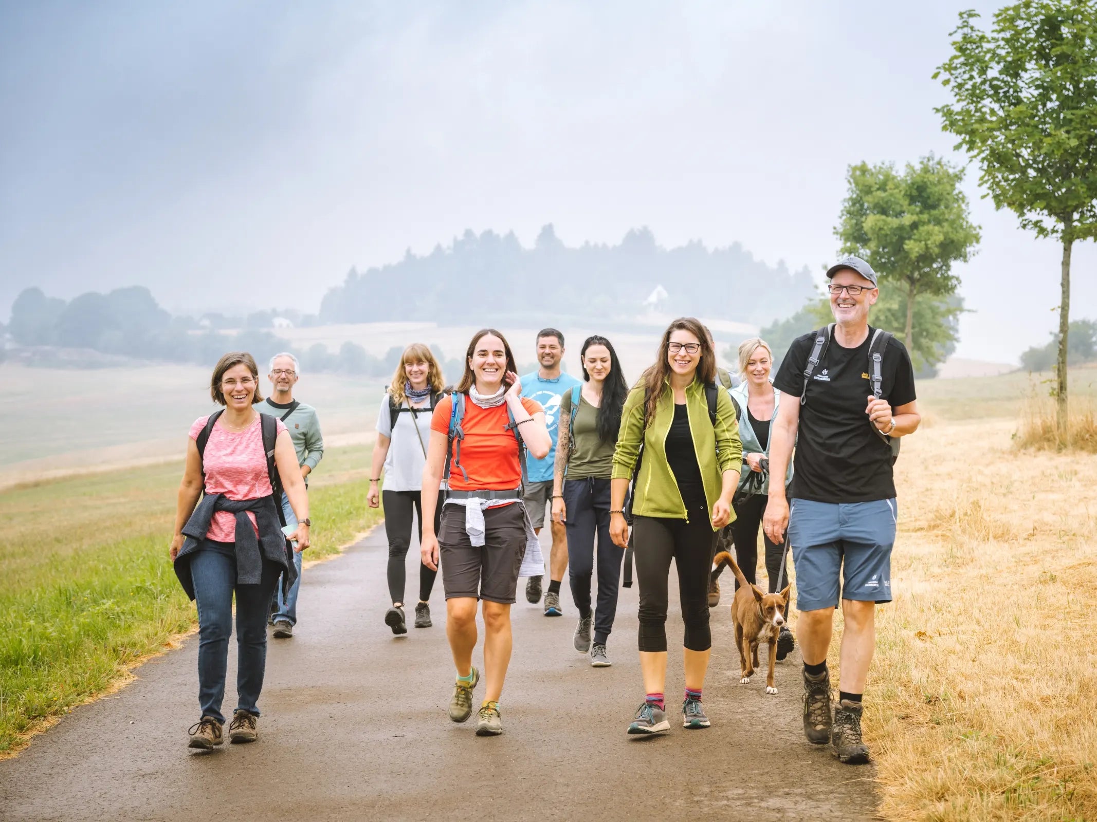 Eine Gruppe genießt die Wanderung auf einem Naturpfad an einem bewölkten Tag Waldführung mit Wohllebens Waldakademie.