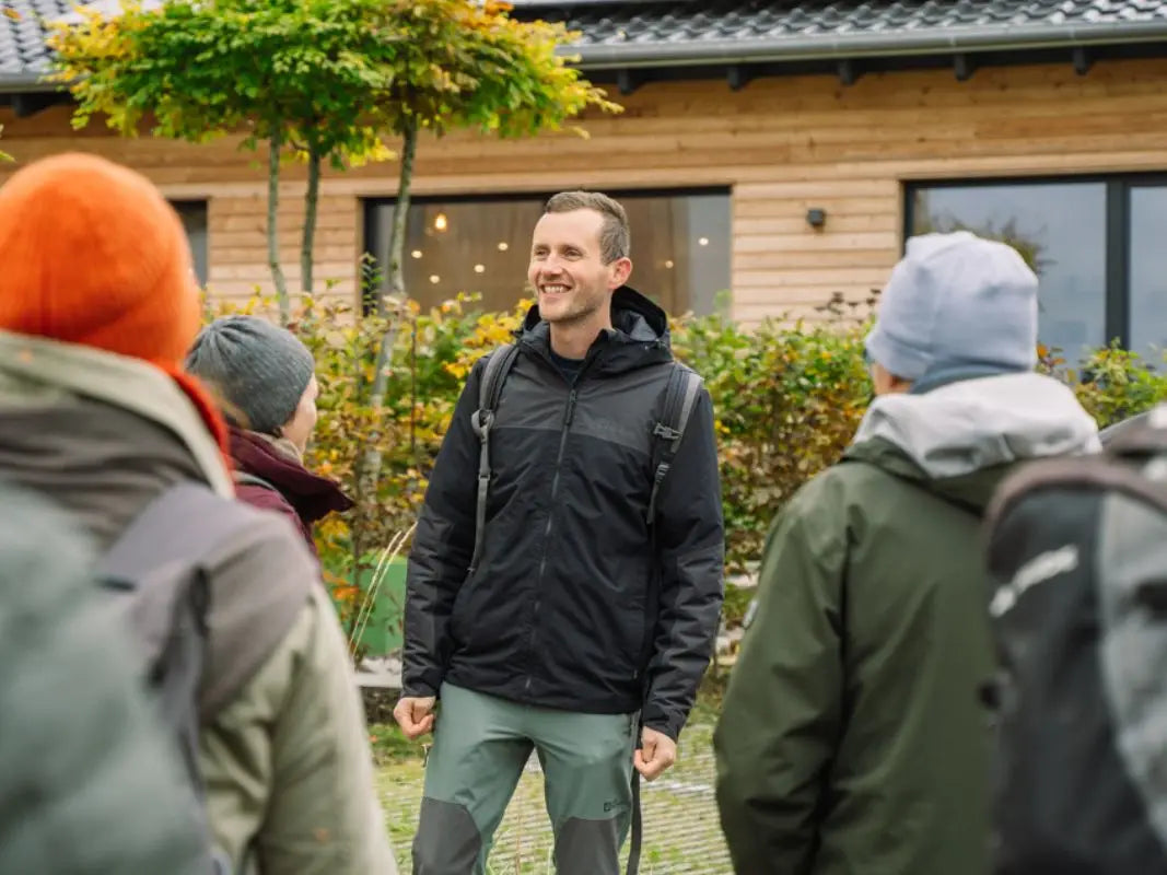 Waldführer begrüßt eine Gruppe am Haus Blattwerk in Wershofen